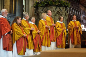 Um grupo de homens e mulheres recebendo as ordenações inválidas.